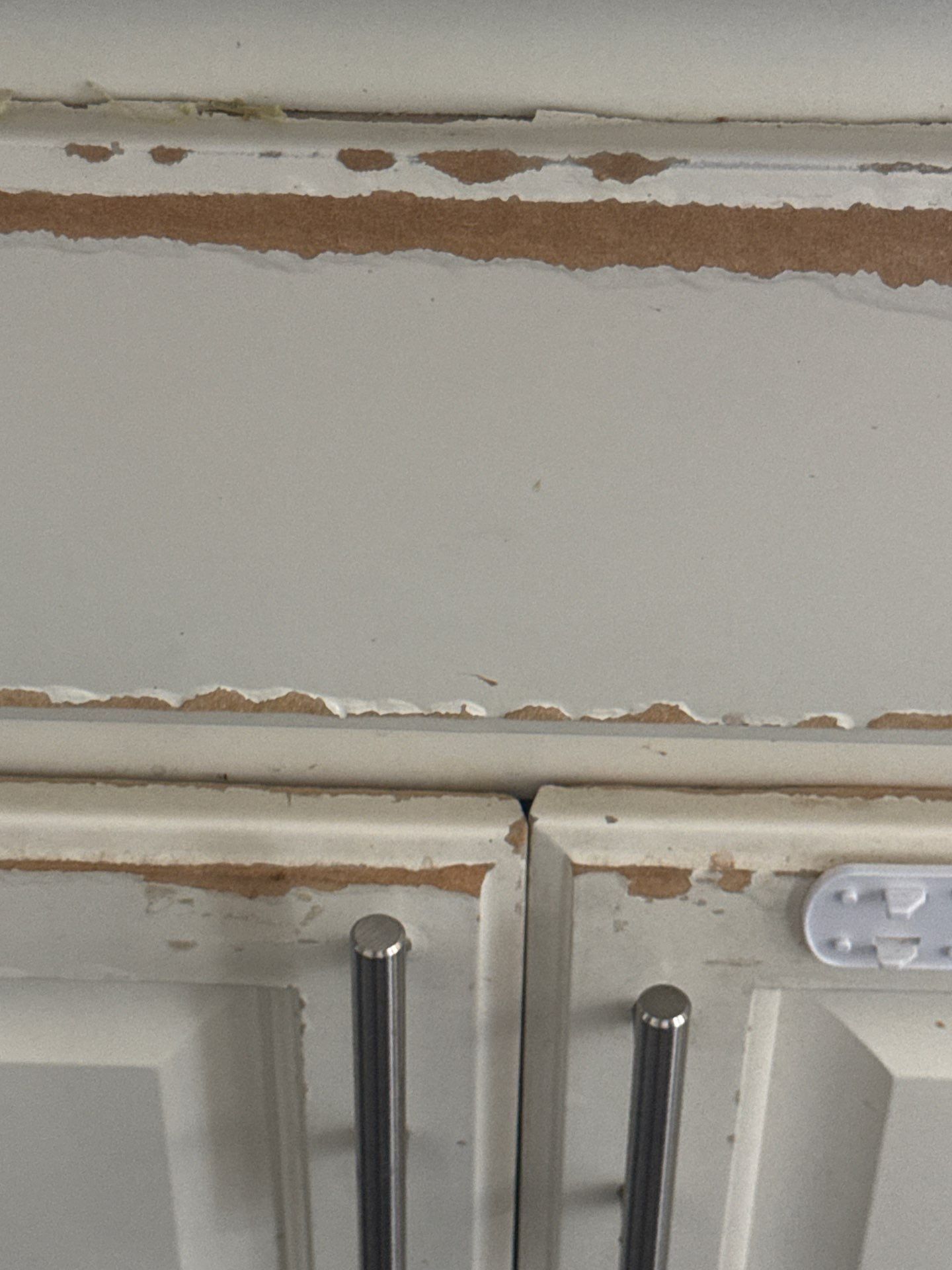 Kitchen cabinet peeling paint detail ahead of refinishing