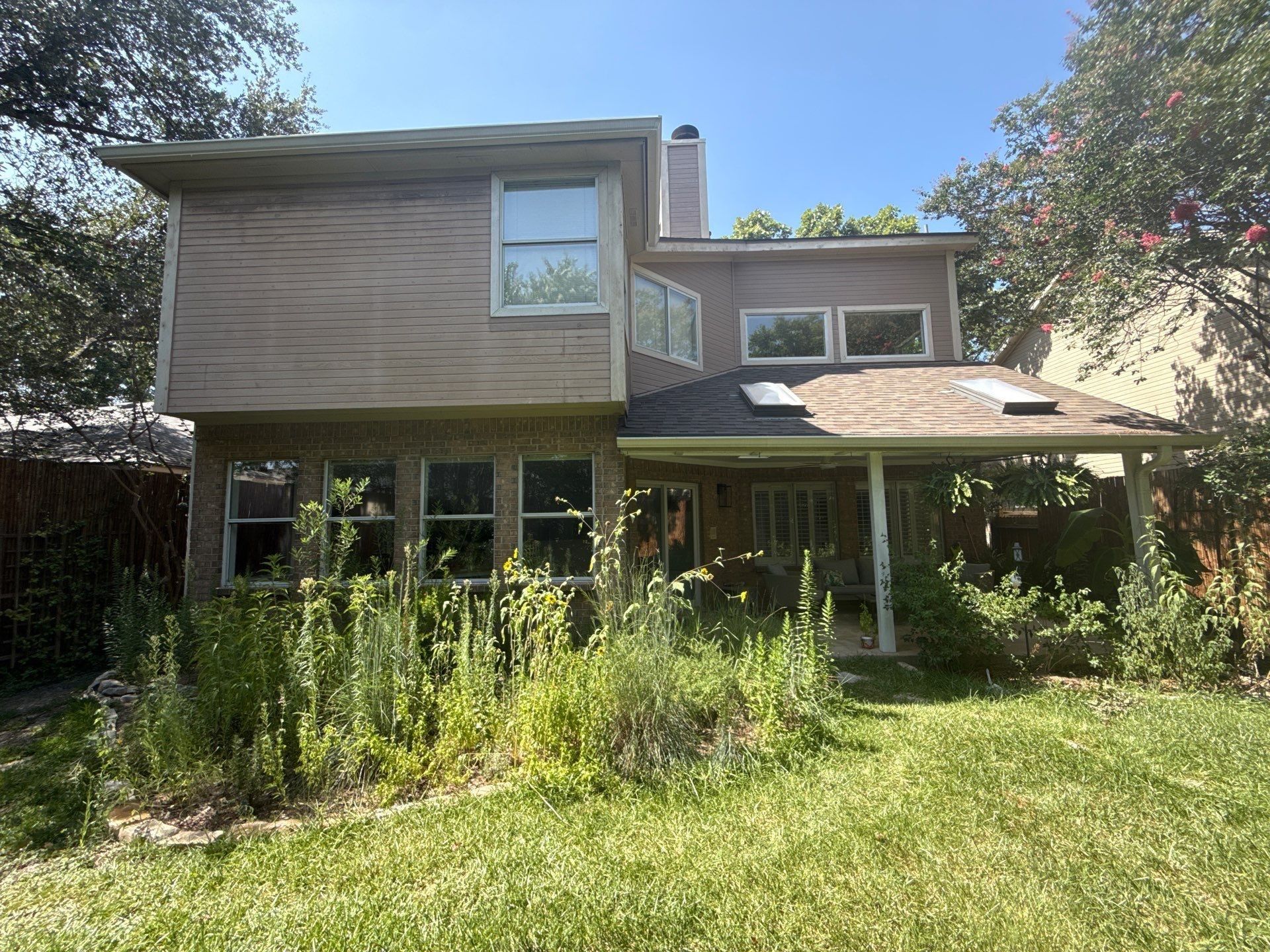 Back exterior of house with covered porch ahead of painting