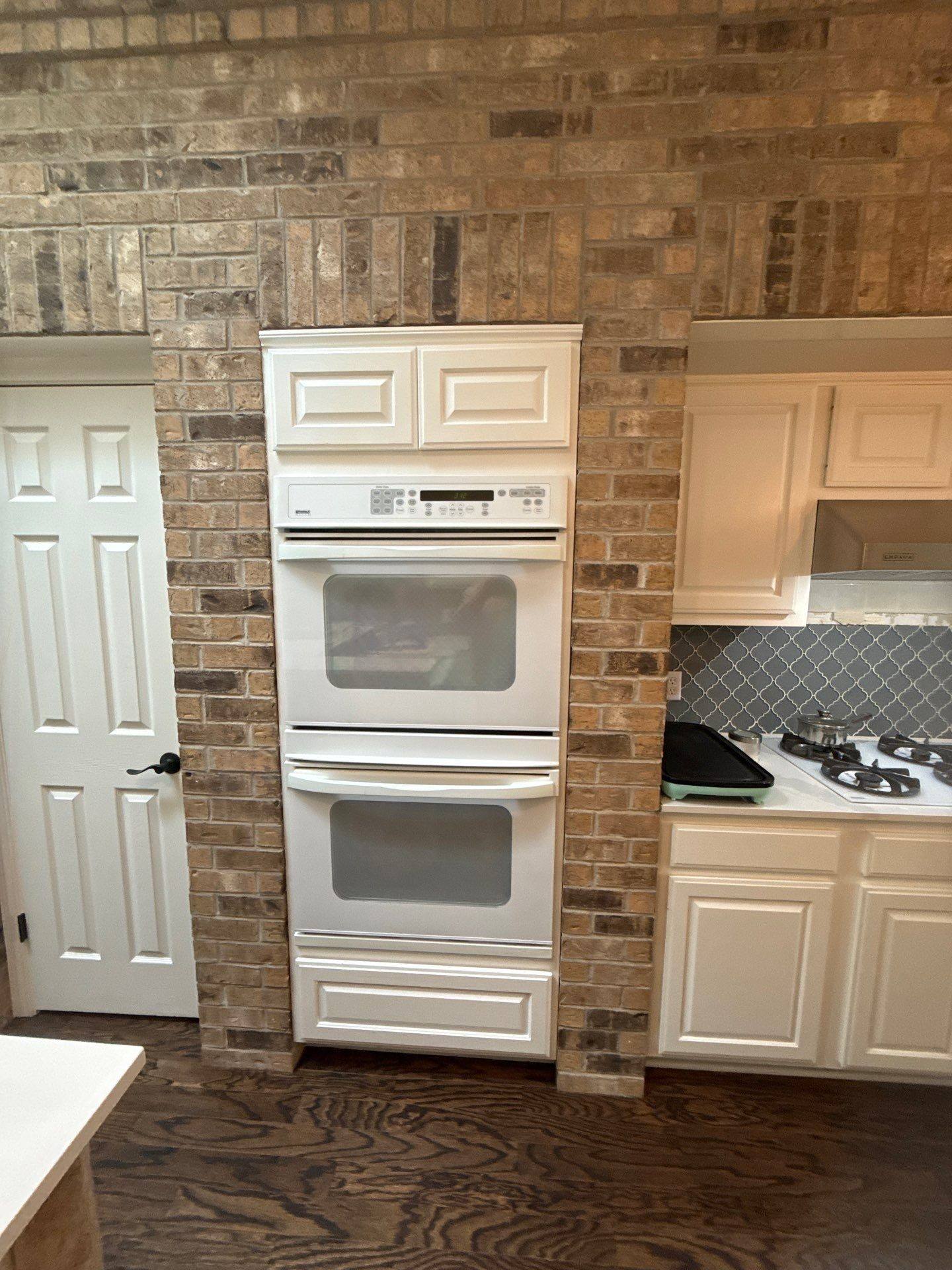 Kitchen double wall oven and cabinetry ahead of refinishing