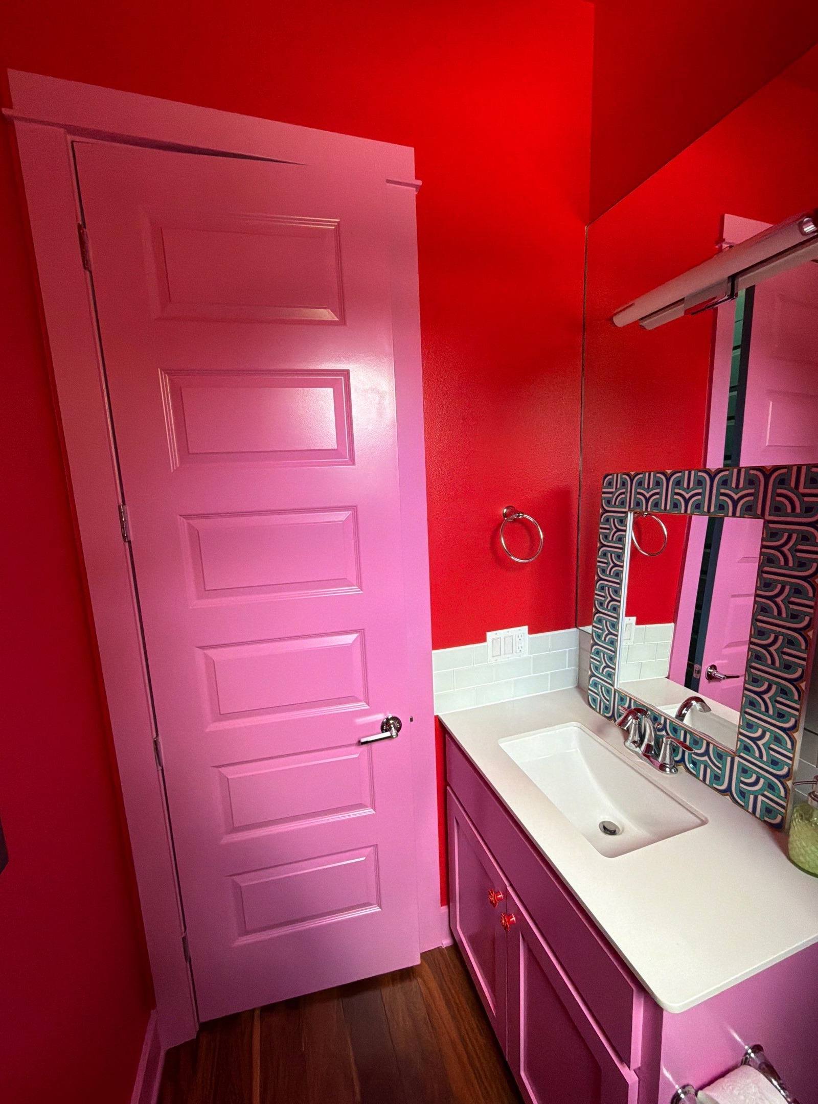 Bold red powder bathroom with magenta vanity from the completed interior painting project