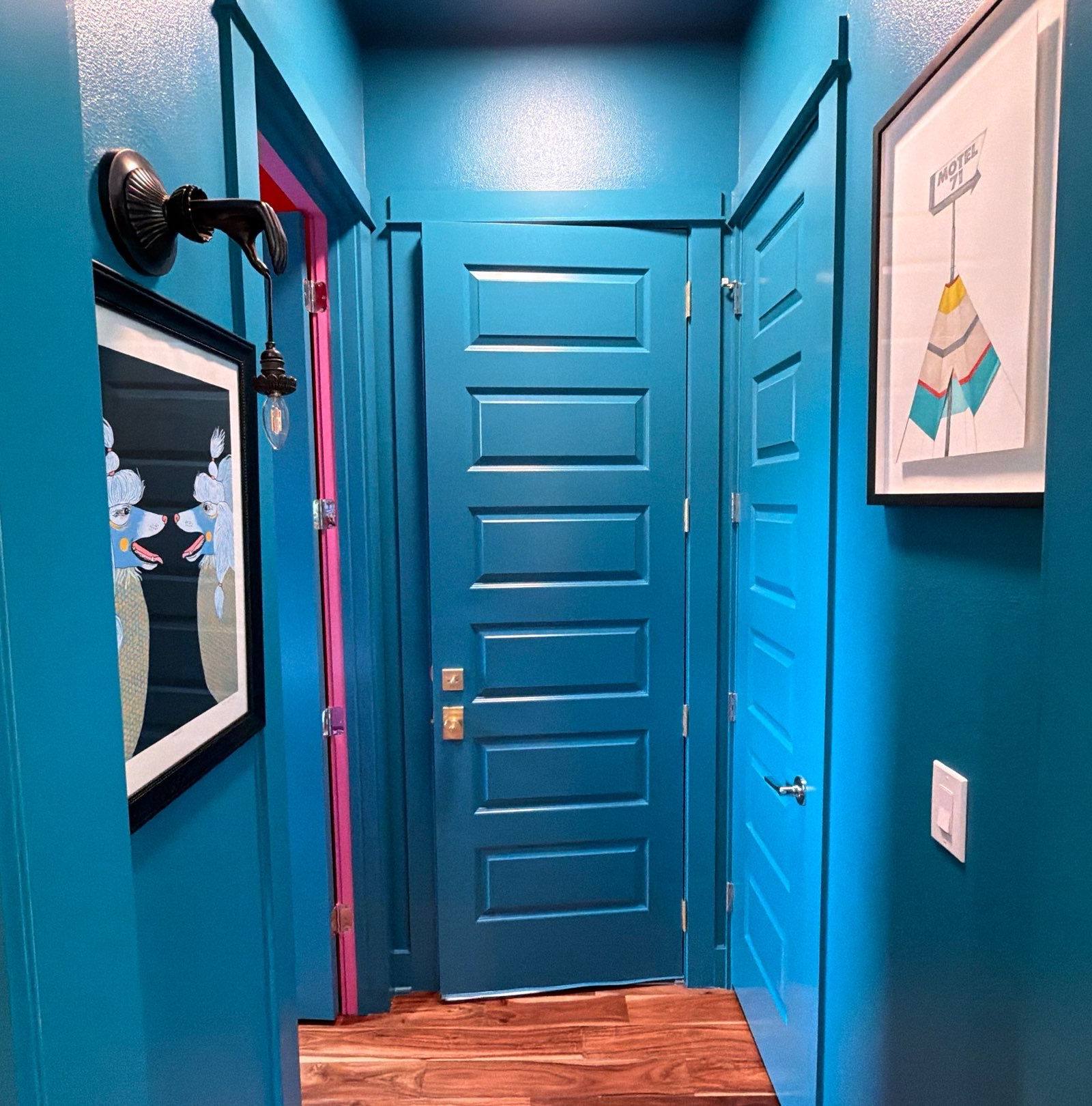 Teal hallway with pink door trim in the Bee Cave home