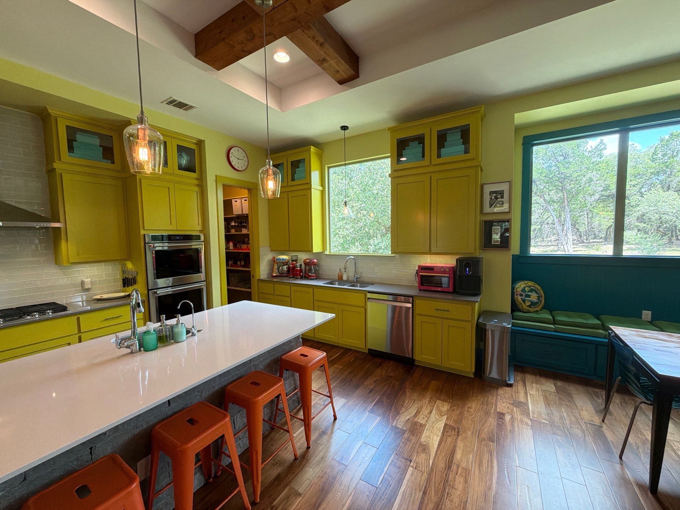 Yellow kitchen with teal built-in banquette seating in the Bee Cave home