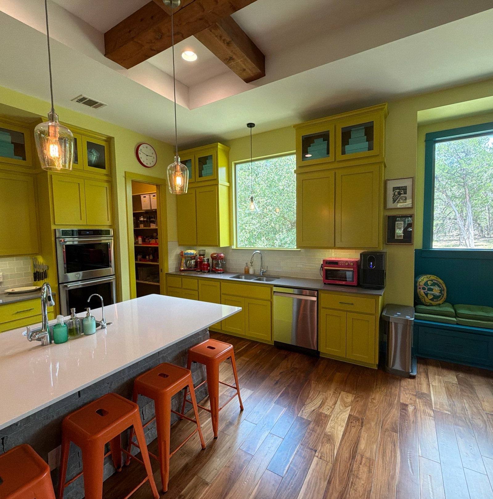 Yellow kitchen with teal built-in banquette seating in the Bee Cave home