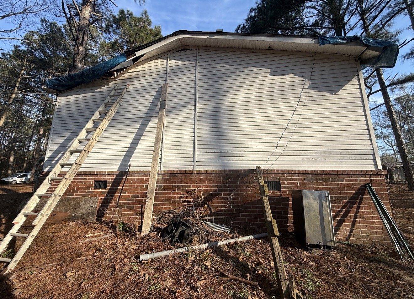 KCC crew tarping a damaged eave and roof edge ahead of permanent repair