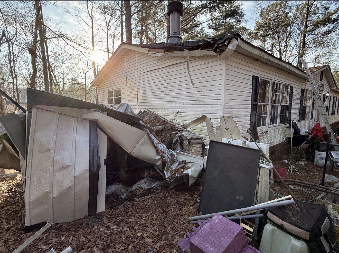 Storm-damaged home with structural debris on site